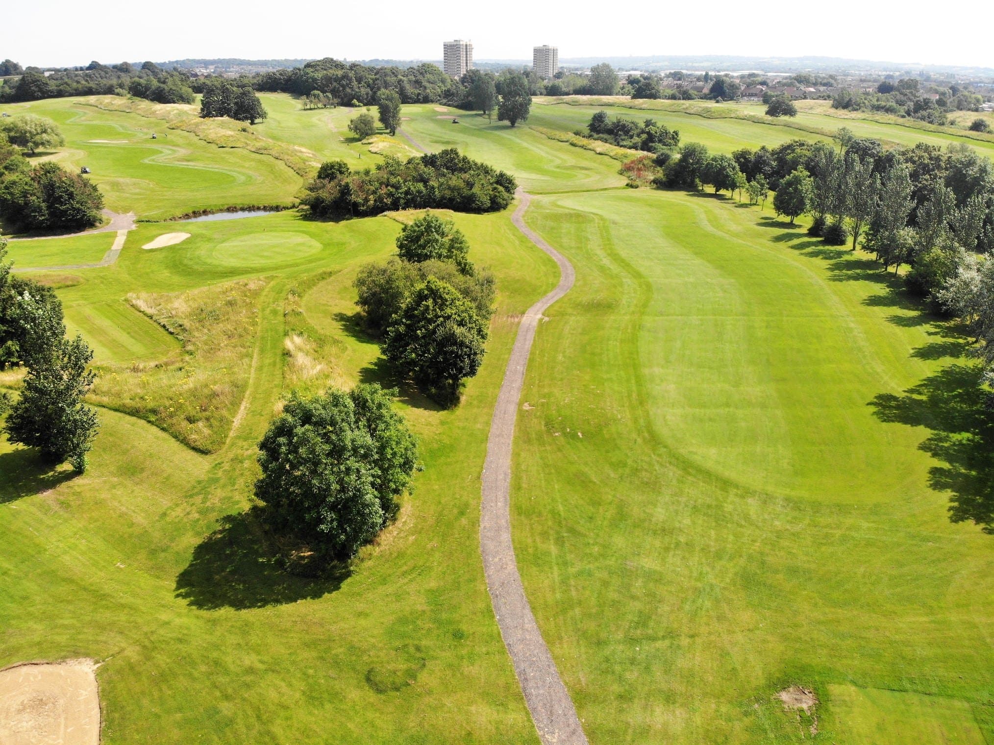 Risebridge from the air: a fairway curving between trees, with the cart path beside it