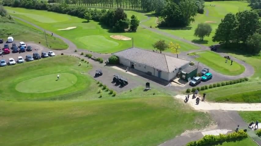 The clubhouse and the green beside it, seen from the air